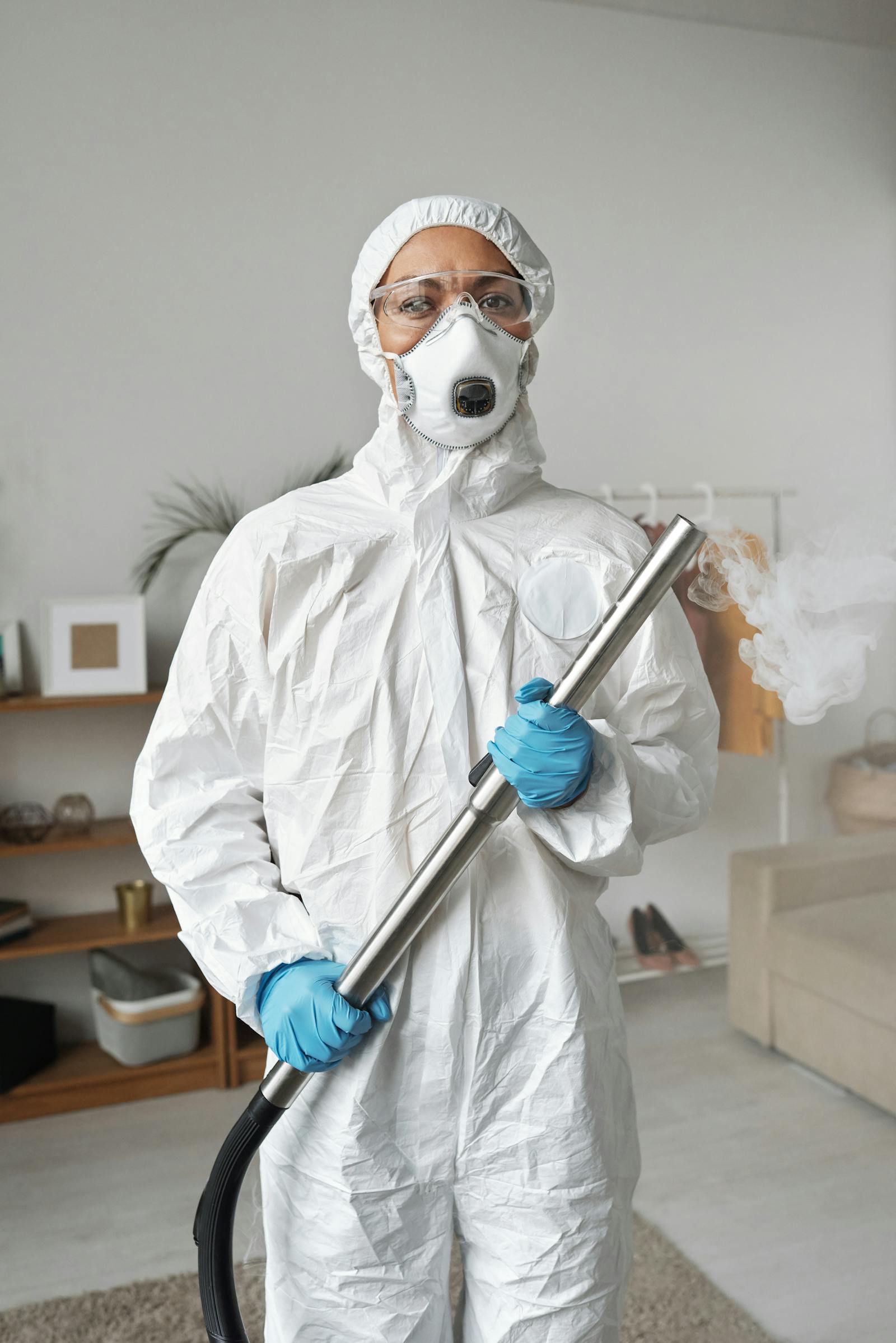 Protective-suit worker holding disinfection equipment