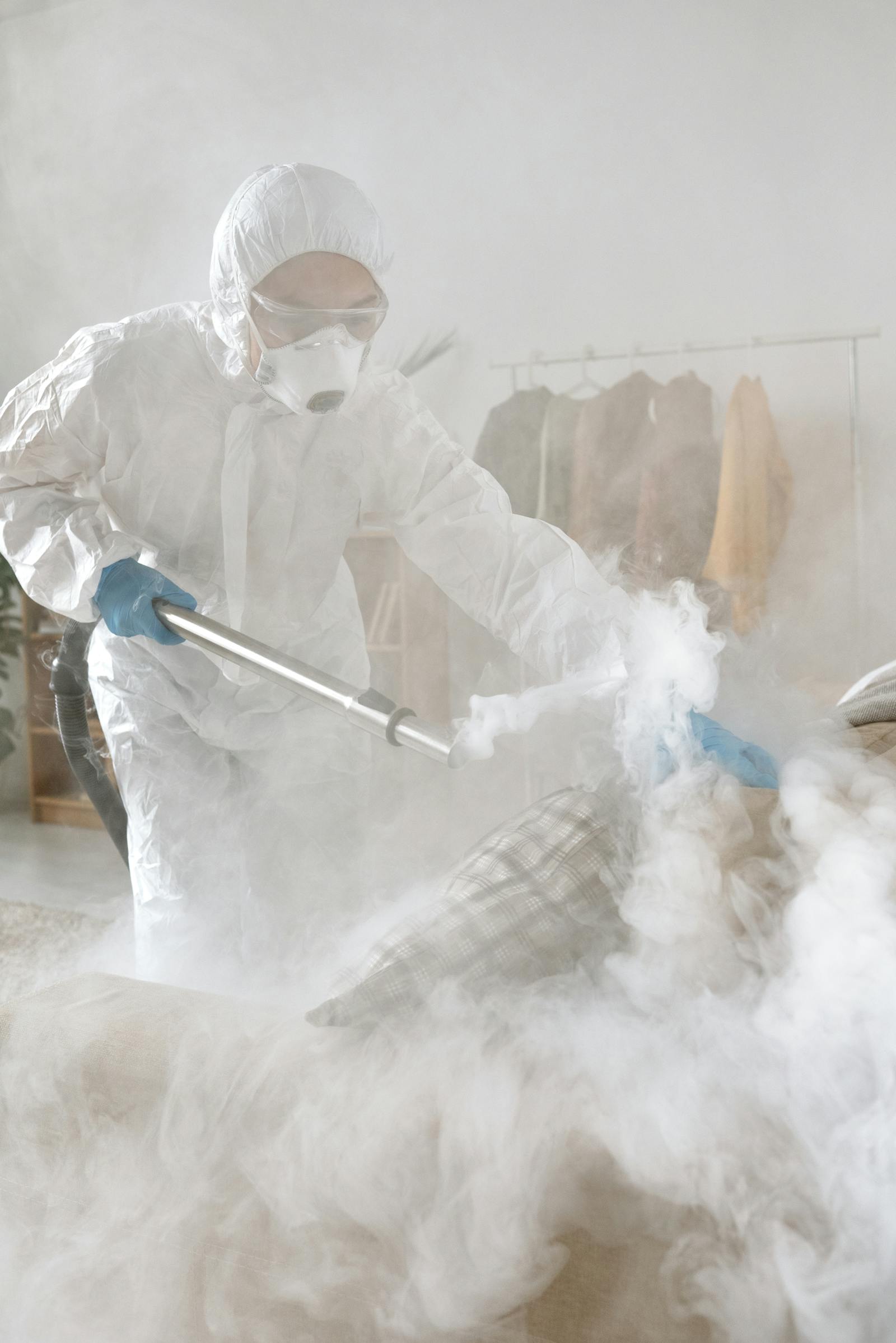 Protective-suit worker fumigating a compact workspace